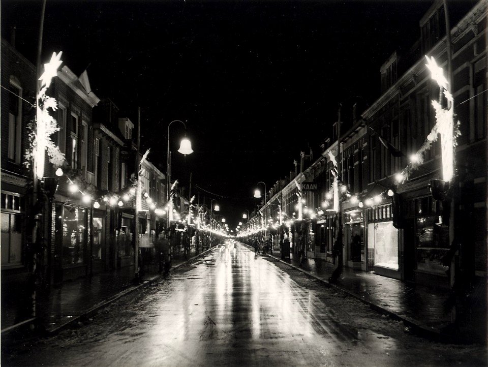 Generaal Cronjéstraat, nabij de Dr. Leijdstraat, ziende naar het zuiden, tijdens de kerst weken, bij avond versierd en verlicht. Aangekocht in 1977 van fotograaf C. de Boer. Identificatienum, NL-HlmNHA 54004651