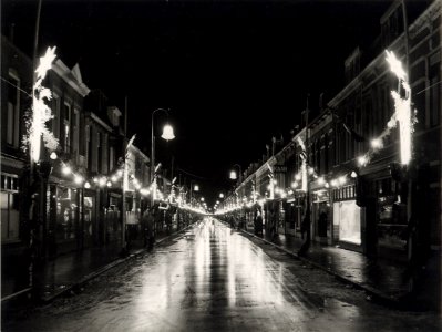 Generaal Cronjéstraat, nabij de Dr. Leijdstraat, ziende naar het zuiden, tijdens de kerst weken, bij avond versierd en verlicht. Aangekocht in 1977 van fotograaf C. de Boer. Identificatienum, NL-HlmNHA 54004651