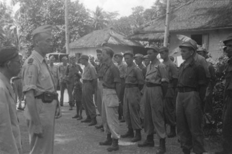 Generaal Dürst Britt spreek een groep militairen toe. Naast hem een Javaanse ma…, Bestanddeelnr 481-5-4