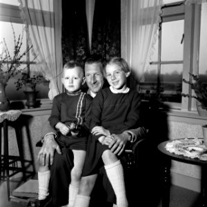 Gerard met zijn beide kinderen op schoot, terwijl ze een fotoalbum bekijken. Lin, Bestanddeelnr 254-3312