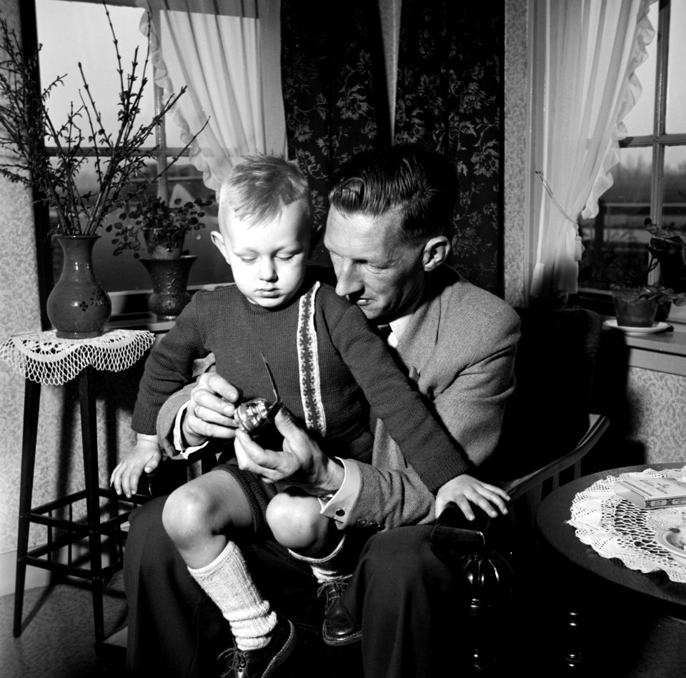 Gerard met zijn vierjarig zoontje Gerrie op schoot met een speelgoed helikopter., Bestanddeelnr 254-3307