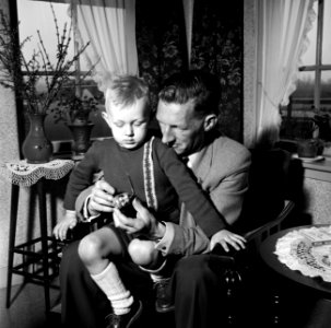 Gerard met zijn vierjarig zoontje Gerrie op schoot met een speelgoed helikopter., Bestanddeelnr 254-3307