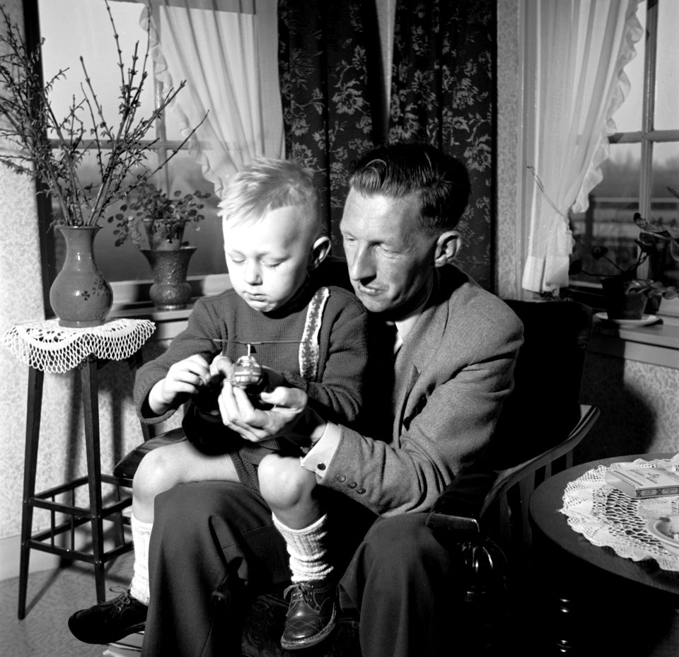 Gerard met zijn vierjarig zoontje Gerrie op schoot met een speelgoed helikopter., Bestanddeelnr 254-3308