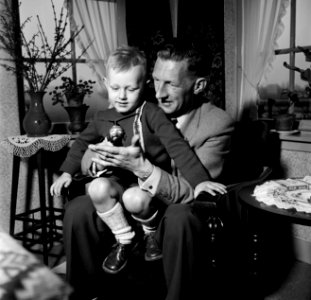 Gerard met zijn vierjarig zoontje Gerrie op schoot met een speelgoed helikopter., Bestanddeelnr 254-3306