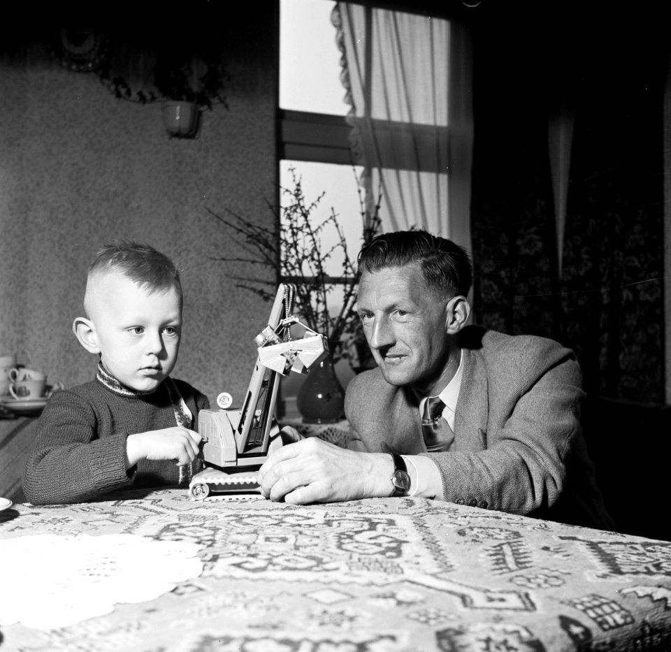 Gerard met zijn vierjarig zoontje aan tafel met een speelgoedhijskraan, Bestanddeelnr 254-3304
