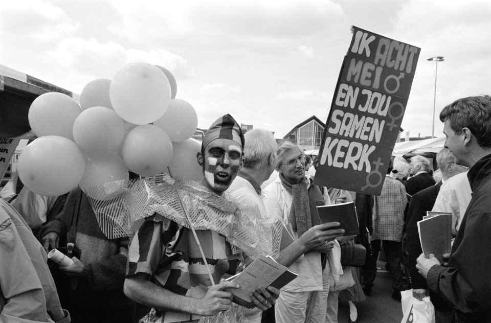 Geschminkte man met ballonnen en man met actiebord, Bestanddeelnr 934-4499