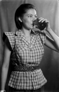 Geposeerde foto. Vrouw drinkt uit een glas, Bestanddeelnr 8738