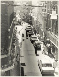 Geparkeerde auto's in de Anegang ziende vanuit de Grote Houtstraat naar het oosten. NL-HlmNHA 54012168