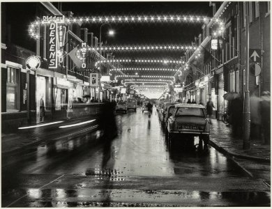 Gen. Cronjéstraat bij avond, met feestverlichting, ziende naar het noorden. NL-HlmNHA 54012065