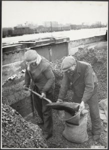 Geen bijschrift Arbeiders scheppen kolen in jute zakken in een open goederenw, Bestanddeelnr 033-0582