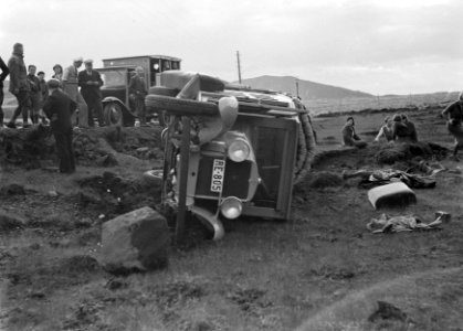 Gekantelde auto naast een weg van voren gezien in een heuvelachtig landschap Pu, Bestanddeelnr 190-0289