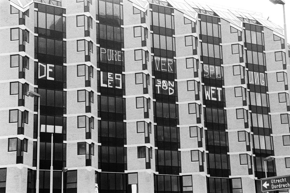 Gekraakte appartementen met tegen de ramen de tekst Peperdure verspilling leegs, Bestanddeelnr 931-2953