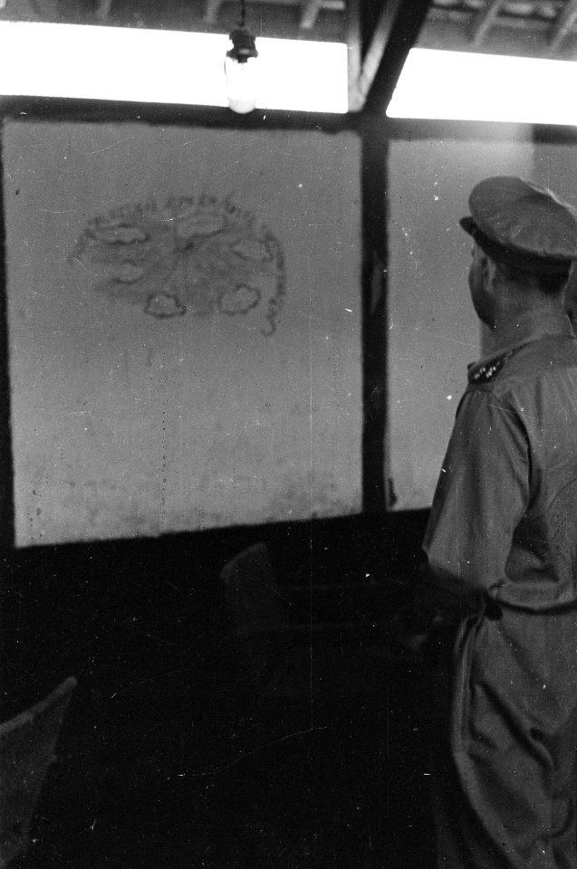 Generaal Kruls bekijkt graffiti op een muur, Bestanddeelnr 4224