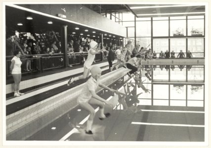 Gemeentelijke Zweminrichting De Planeet. Kinderen springen in het water tijdens de opening., NL-HlmNHA 54003655