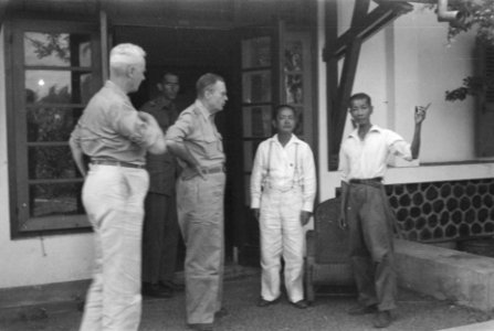 H.J. van Mook met zijn armen in zijn zij praat met Chinese inwoners, Bestanddeelnr 10-1-2