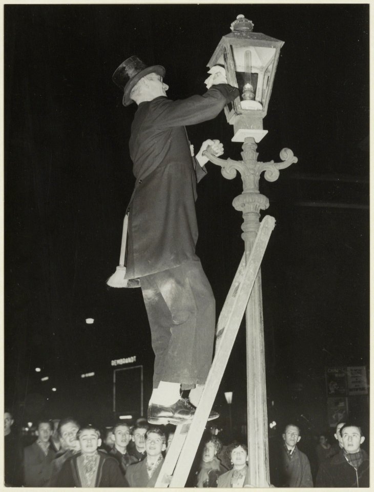 Haarlem Lichtstad 1953. Lantaarnopsteker bij de Riviervismarkt. NL-HlmNHA 54004653