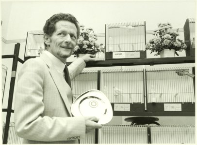 Haarlemse Vogelvereniging Onderling Genoegen. Kweker J. Damsteek is kampioen en mocht het nationale bondskruis alsmede een bord in ontvangst nemen. NL-HlmNHA 5400466920