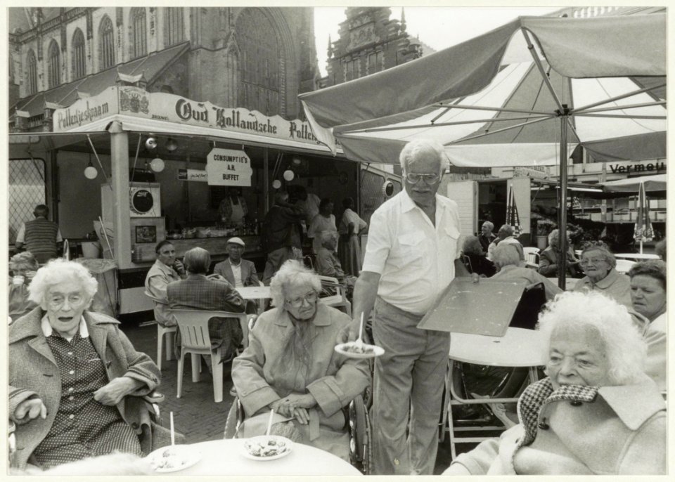 H. Brouwer van de poffertjeskraam deelt ter gelegenheid van zijn 76ste verjaardag poffertjes uit. NL-HlmNHA 54032062