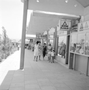 Halfoverdekt winkelcentrum met winkelende vrouwen met ijsetende kinderen, Bestanddeelnr 255-3082