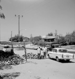 Handelaar met meloenen langs de weg met een weegschaal en autoverkeer en telefoo, Bestanddeelnr 255-4281 photo