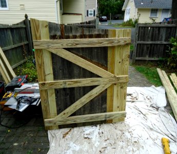 Handyman project repairing a gate with new slats and springs and latches