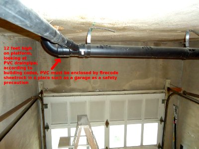 Handyman project -- View of exposed PVC drain pipe in garage from scaffolding photo