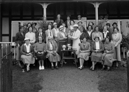 Group of women outside Llandrindod Wells Golf Club pavilion, with a lady golfer being presented with a cup (1294914)