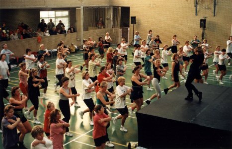 Groot aerobicsfeest in de Zandvoortse Van Pageehal. Aangespoord door aanwijzigingen van Debbie Jenner op het podium bewegen de ruim honderd vrouwen op de beat van de muziek. Aangekocht in 1996 van Uni
