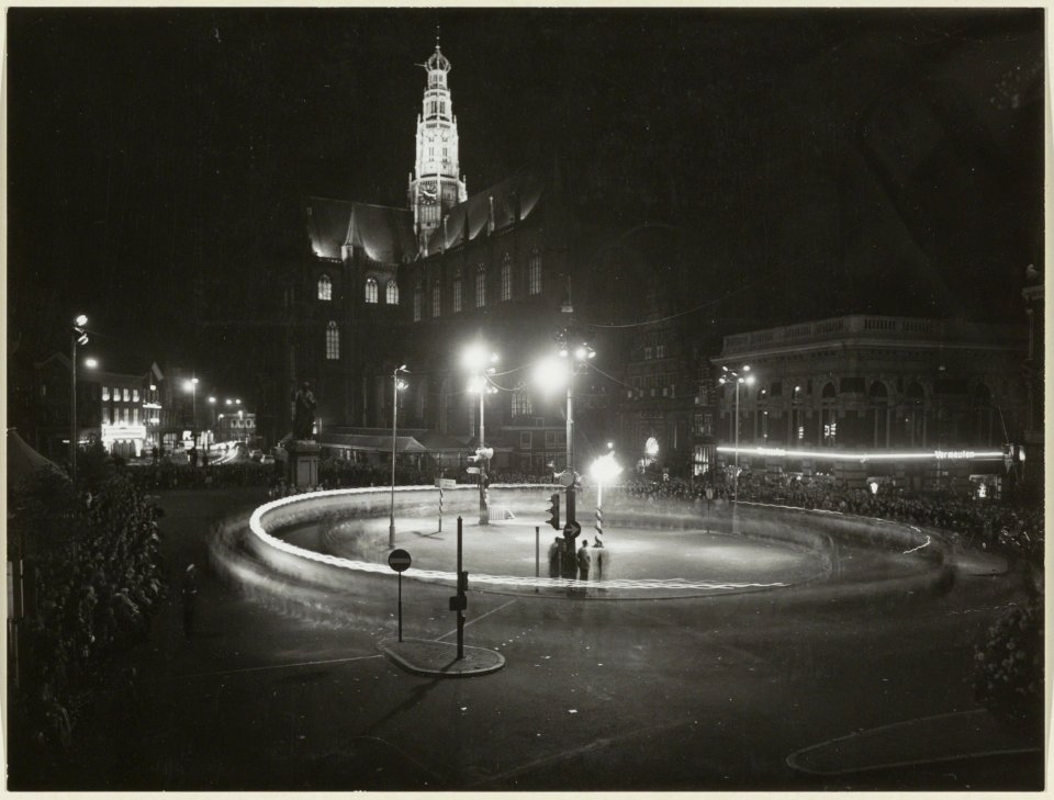 Grote markt, ziende naar het oosten, bij avond met extra verlichting en de toren van de Grote Kerk in Flood Light. NL-HlmNHA 54004654