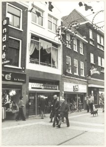 Grote Houtstraat tussen de Anegang en de Spekstraat. ziende naar het zuidoosten. Links lunchroom Fluks. NL-HlmNHA 54010164