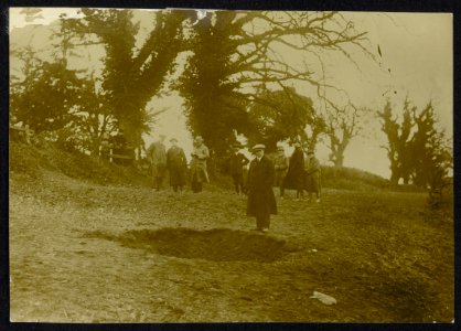 Groep burgers bekijkt een krater tussen de bomen van een bos., Bestanddeelnr 158-1299