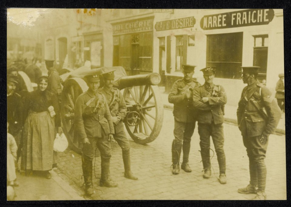 Groepje Amerikaanse soldaten bij een kanon in een Franse dorpsstraat met burgers, Bestanddeelnr 158-1338