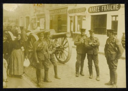 Groepje Amerikaanse soldaten bij een kanon in een Franse dorpsstraat met burgers, Bestanddeelnr 158-1338
