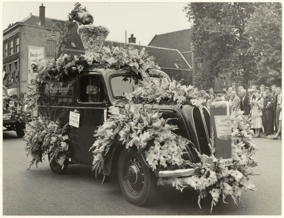 Grote Houtbrug met versierde wagens van het bloemencorso 1952. NL-HlmNHA 54010468