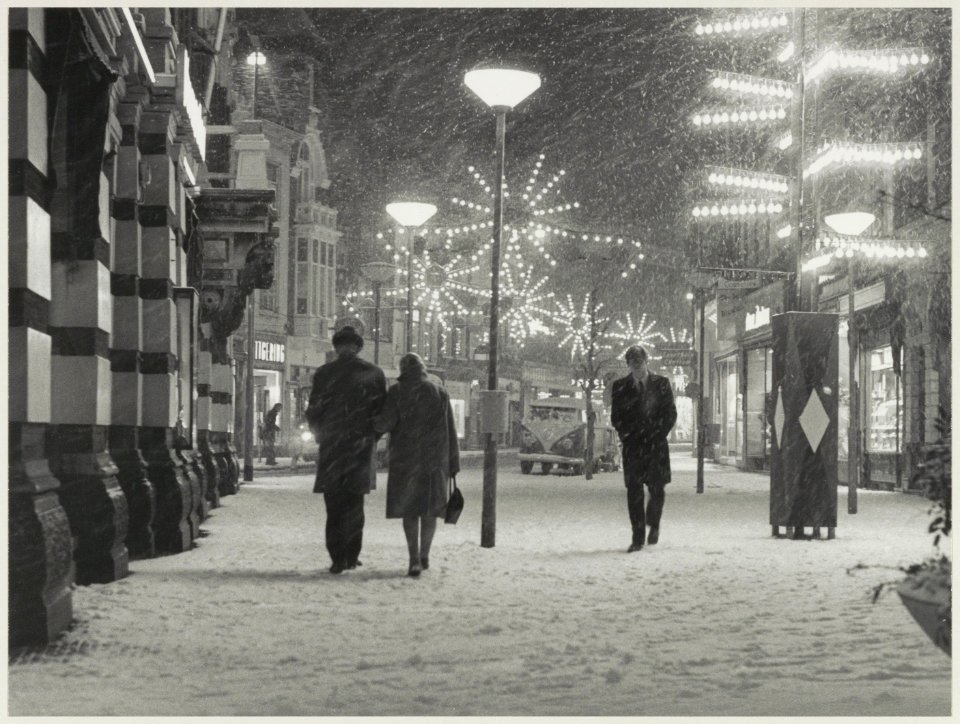 Grote Houtstraat, gezien naar het zuiden vanaf de Grote Markt, met sneeuw en kerstverlichting. NL-HlmNHA 54011713
