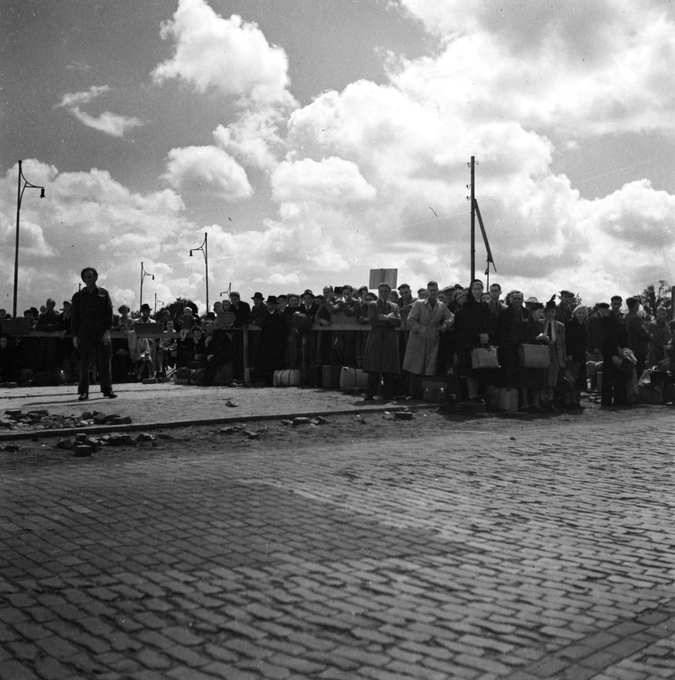 Grote groep mensen met bagage langs een weg, Bestanddeelnr 900-6024