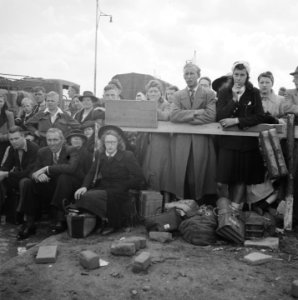 Grote groep mensen met bagage langs een weg, Bestanddeelnr 900-6026
