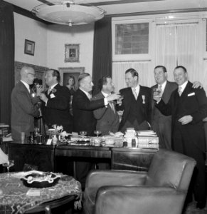 Groep mannen poserend met glazen drank achter bureau, 2e van links Jan van Abbe , Bestanddeelnr 255-8455
