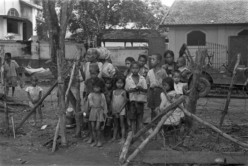 Groep Indonesische kinderen in haveloze kleding tussen prikkeldraadversperringen, Bestanddeelnr 125A-1-5