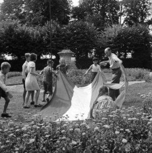 Groep kinderen en een man bezig met een vlag, Bestanddeelnr 900-5901