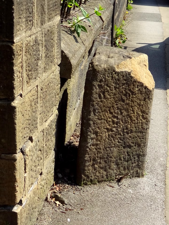 Gritstone pillar with three cup marks in the north pavement of the A65 at Horsforth, 440m south east of the roundabout at Low Fo