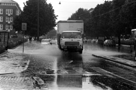 Het autoverkeer rijdt door de plassen met opspattend water, Bestanddeelnr 928-1133