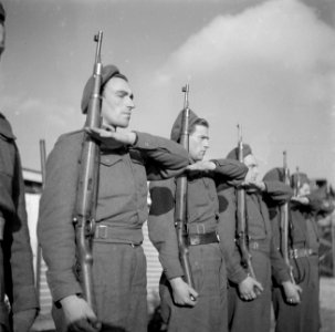 Groep militairen presenteert geweer, Bestanddeelnr 255-9444