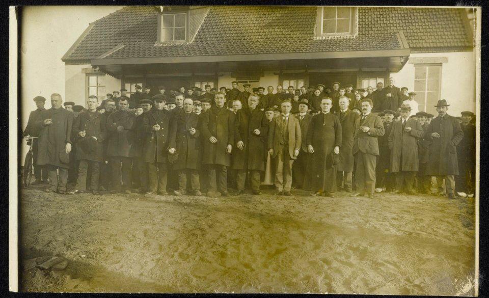 Groep mannen waar onder enige Rooms-katholieke priesters voor een gebouw., Bestanddeelnr 158-1270