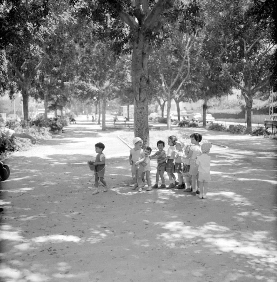 Groep spelende kinderen in de schaduw van een boom aan de Rothschild Boulevard, Bestanddeelnr 255-1755
