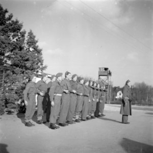 Groep militairen staan aangetreden in een kamp, Bestanddeelnr 255-9443