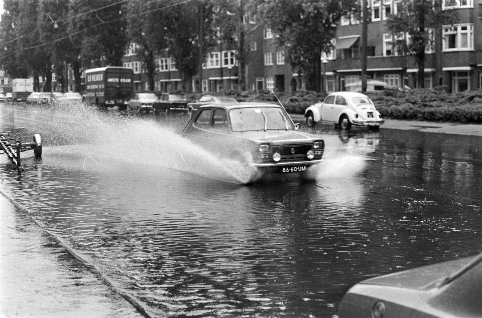 Het autoverkeer rijdt door de ondergelopen straten met opspattend water, Bestanddeelnr 928-1132