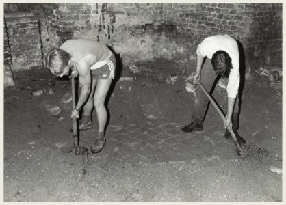 Het afpellen van een aardlaag, waaronder eeuwenlang een duurzame baksteenvloer verborgen heeft gelegen in de kapeltoren van de Ruïne van Brederode. NL-HlmNHA 54013846