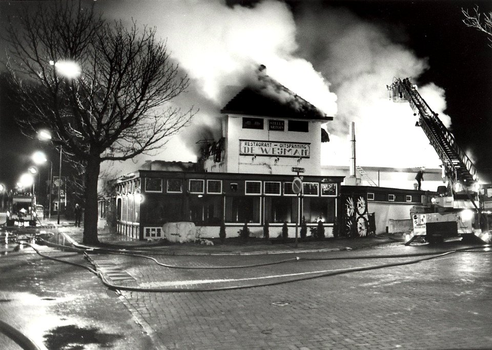 Het afbranden van Café Restaurant De Weijman, aan de Hoofdstraat hoek Wüstelaan, ziende naar het zuiden. Aangekocht in 1983 van fotograaf C. de Boer. - Negatiefnummer 21403 k 20 a. - Gepubli, NL-HlmNHA 54013094