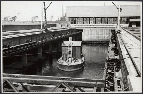 Herstelwerk aan de sluizen van IJmuiden Met behulp van een boot worden in de ni, Bestanddeelnr 512 042
